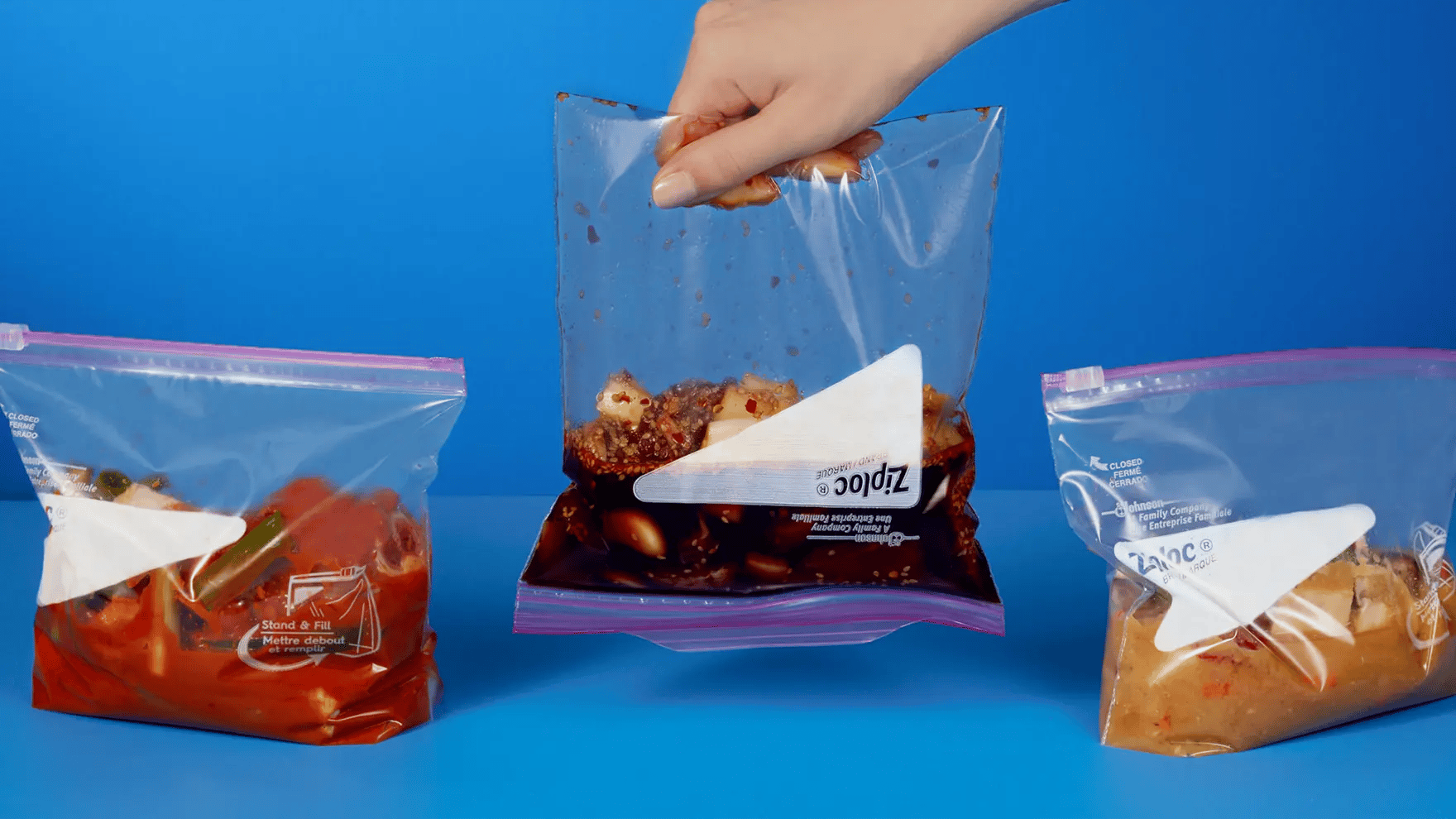 3 saveurs de marinades coréennes dans des sacs Ziploc qu’on est en train de soulever